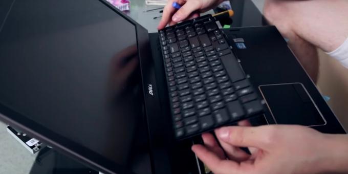 المزالج الوسيط حدق في محيط من لوحة المفاتيح وبعناية رفع إلى جهاز الكمبيوتر المحمول نظيفة